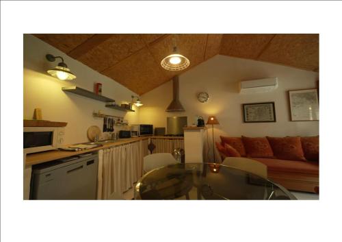 une cuisine et un salon avec une table et un canapé dans l'établissement giteducheminduboutduvillage, à Montégut