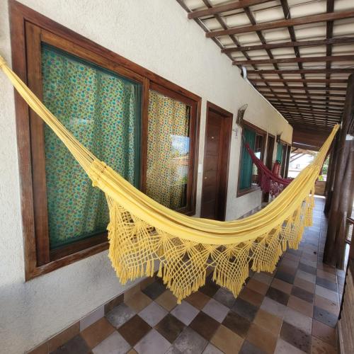 a hammock hanging from a wall in a room at Pousada Aconchego de Genipabu in Jenipabu