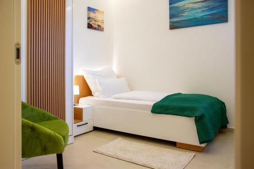 a small bedroom with a bed and a chair at JOELL Apartments in Lokva Rogoznica