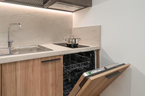 a kitchen with a sink and an empty dishwasher at Residence Al Frantoio in Arco