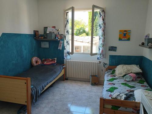 马赛Maison individuelle avec jardin的有两张床和一扇窗户的卧室