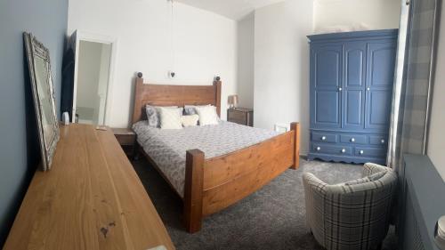 a bedroom with a bed and a blue cabinet at Family house in Oldham