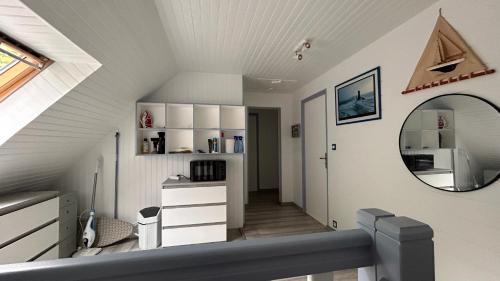 a attic room with a mirror and a staircase at Entre terre et mer in Combrit