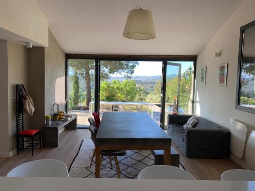- un salon avec une table en bois et une grande fenêtre dans l'établissement Villa Sainte Victoire, au Tholonet