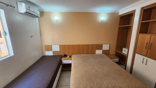 a small room with a bed and a desk at diRoma Fiori - Apartamentos JN in Caldas Novas