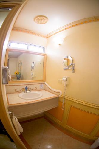 a bathroom with a sink and a mirror at Villa las Margaritas Plaza Cristal in Xalapa