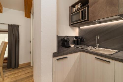 a kitchen with a sink and a microwave at Residence Al Frantoio in Arco