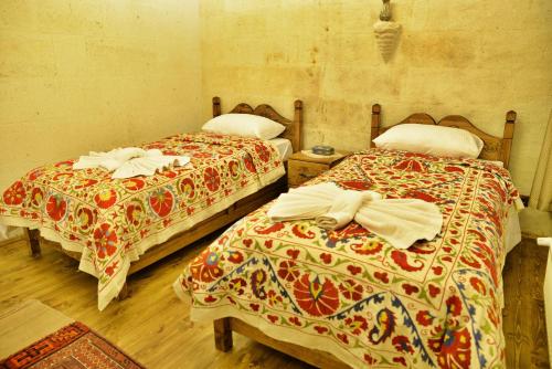 two beds sitting next to each other in a room at Ürgüp Inn Cave Hotel in Urgup