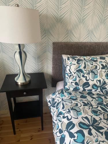 a bedroom with a bed and a lamp on a table at Holiday Home Waterville in Waterville