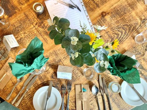 a wooden table with plates and flowers on it at Ashton Court Hotel in Exmouth
