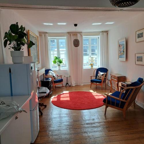 - un salon avec un tapis rouge sur du parquet dans l'établissement Lumière et Confort en Centre Ville, à Huelgoat