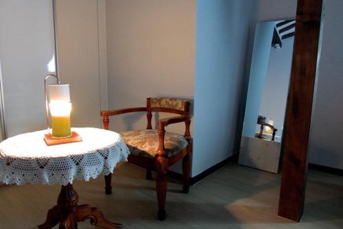 a room with a chair and a candle on a table at Naju DorandoranHouse Hanok in Naju