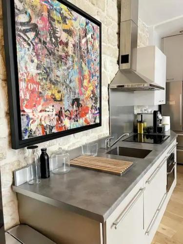 un comptoir de cuisine orné d'une peinture murale. dans l'établissement Contemporary apartment 150 meters from Place Victor Hugo Paris 16, à Paris