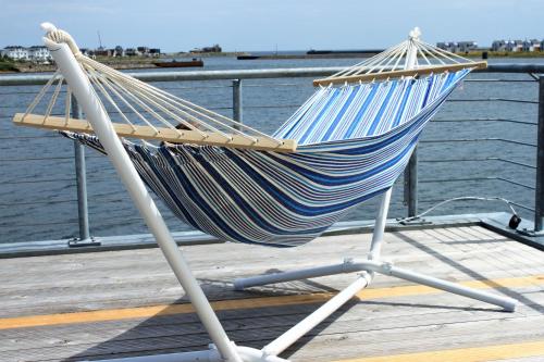 a hammock sitting on a dock next to the water at Wasserhaus Yellow submarine in Olpenitz