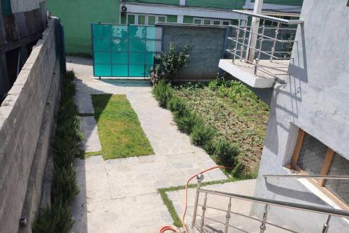 a garden with plants in a yard next to a building at 2 BHK Apartment in Srinagar in Srinagar