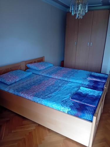 a bedroom with a bed with a blue comforter at Felikitas in Smederevo