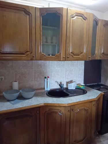 a kitchen counter with wooden cabinets and a sink at Felikitas in Smederevo