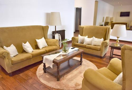a living room with two couches and a coffee table at Hotel Caupolican by Visionnaire in San Martín de los Andes