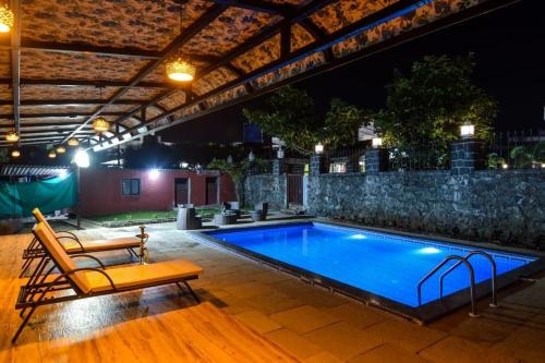 ロナバラにあるLifeline Villas - Exclusive 2bhk Taraangan Farm With Huge Private Pool And Lawn Areaの夜間の庭の中のスイミングプール