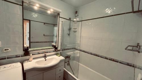 une salle de bain avec un lavabo, une douche et un miroir dans l'établissement Appartement sable et océan, à Saint-Jean-de-Monts