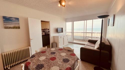 - un salon avec une table et une vue sur l'océan dans l'établissement Appartement sable et océan, à Saint-Jean-de-Monts