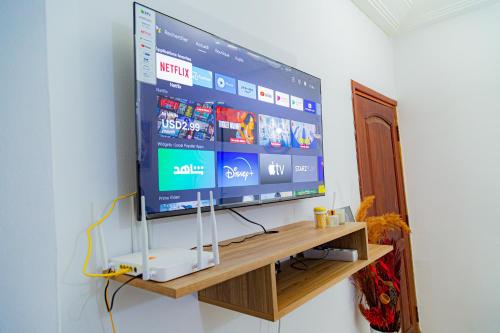 a large flat screen tv sitting on a wooden shelf at Studio Elma in Abidjan