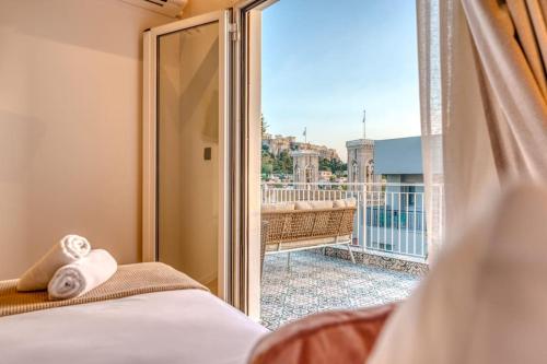 1 dormitorio con puerta corredera de cristal que da a un balcón en Luxury Apt with Acropolis view Balcony and Jacuzzi, en Atenas