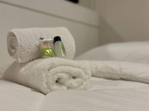 a white towel with a toothbrush in it on a bed at Ap Moderno Ap 21 Soho Life in Curitiba