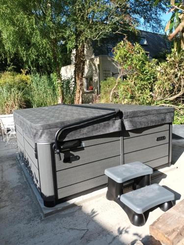 a large barbecue grill with a pair of stools at La maison bric et broc in Saint-Carreuc