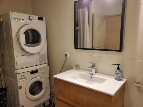 a bathroom with a sink and a washing machine at Lac Saint-Point au balcon in Malbuisson