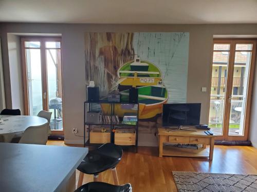 a living room with a table and a boat on the wall at Lac Saint-Point au balcon in Malbuisson