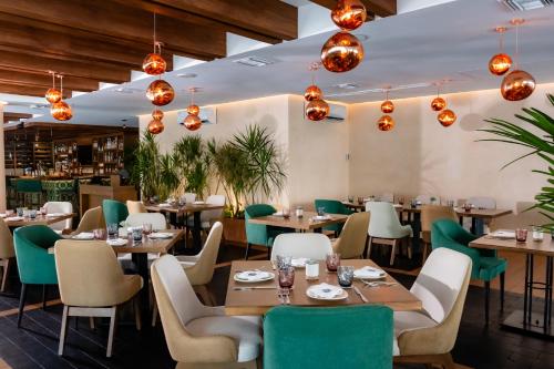a restaurant with wooden tables and chairs and lights at The Reef 28 Hotel & Spa - Luxury Adults Only - All Suites - With Optional All Inclusive in Playa del Carmen