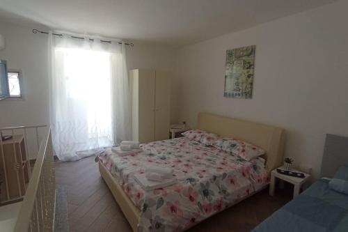 a bedroom with a large bed and a window at Nicaredda in Catania