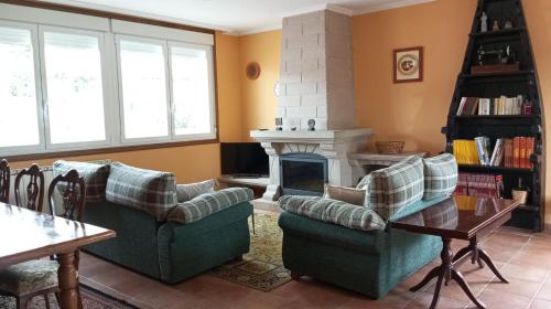 salon z dwiema kanapami i kominkiem w obiekcie Casa a Trepa w mieście Villar de Barrio