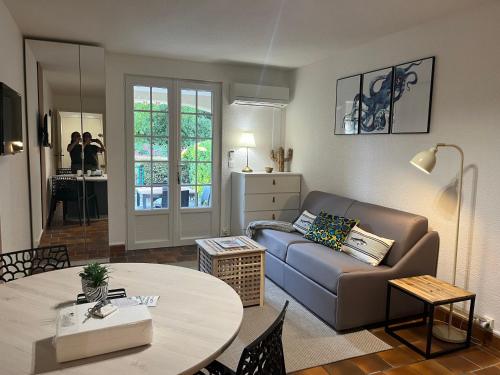 un salon avec un canapé et une table dans l'établissement Bastidon, front de mer jardin parking, saint raphael, à Saint-Raphaël