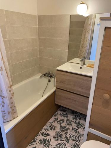 une salle de bain avec une baignoire et un lavabo dans l'établissement Studio cabine vue mer saint pierre la mer, à Fleury