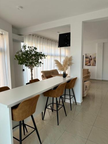 a kitchen and dining room with a white counter and chairs at Medjugorje Apartment Andrea in Međugorje