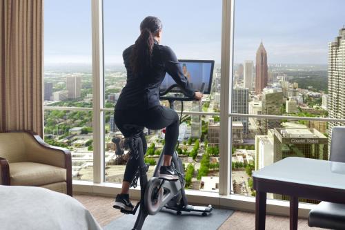 a woman sitting on an exercise bike in front of a window at The Westin Peachtree Plaza, Atlanta in Atlanta