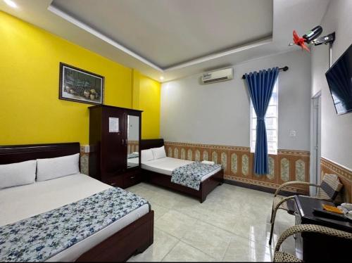 a hotel room with two beds and a window at Tien Dat Motel in Pleiku