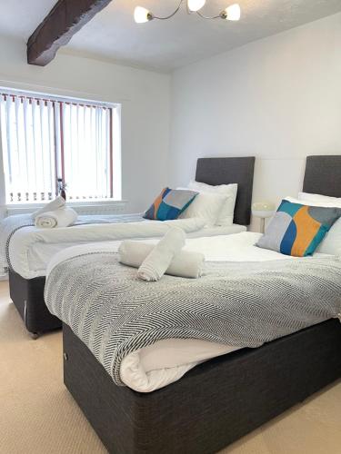 two beds sitting next to each other in a bedroom at Mount Yard - Stylish Cottage - Close to Alton Towers - Peak District - Stoke-on-Trent Sleeps 5 in Totmonslow