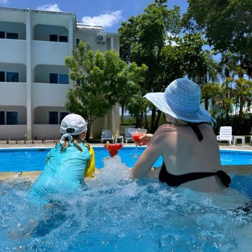 a woman and a child playing in a swimming pool at Tropical Casa Laguna in Cabarete