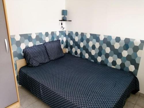 - un lit avec une tête de lit, un oreiller et un miroir dans l'établissement Studio au coeur de la Vendée, à Thorigny