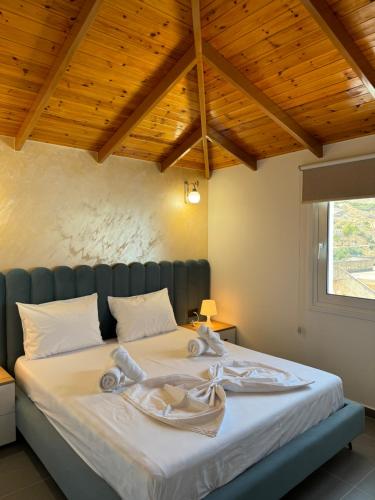 a bedroom with a large bed with wooden ceilings at Adem Hillcrest Apartments in Sarandë