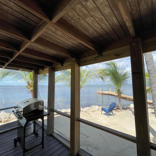 a screened in porch with a view of the beach at Kings Kamp in Key Largo