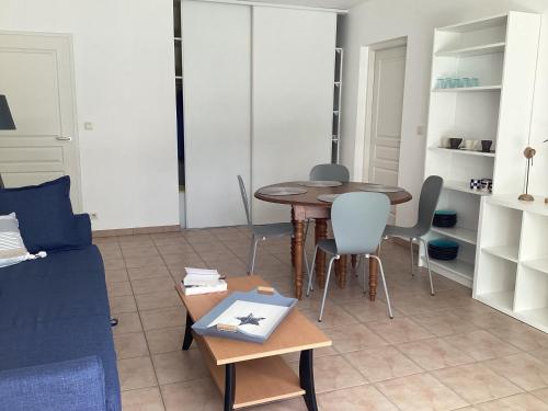 un salon avec une table, des chaises et un canapé dans l'établissement Type 2 rue Alsace lorraine 10mn plage, à La Rochelle