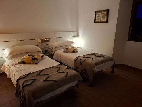 two beds in a hotel room with two at El Albergue de Sigüenza in Sigüenza