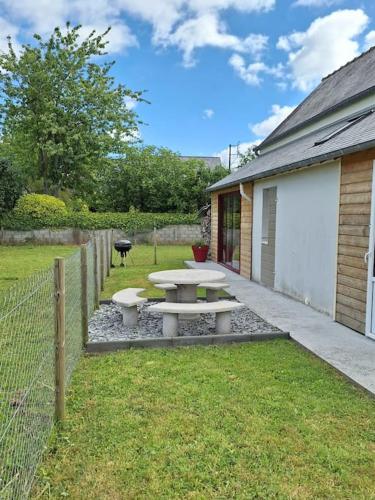 - une table de pique-nique dans une cour à côté d'un bâtiment dans l'établissement La petite maison proche du Mont Saint Michel, à Pontorson