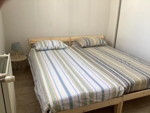 un lit avec deux oreillers dessus dans une chambre dans l'établissement Type 2 rue Alsace lorraine 10mn plage, à La Rochelle