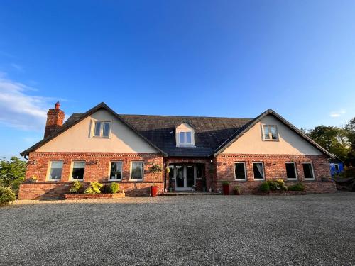 a large brick house with a large driveway at The Starlings Country House in Wexford