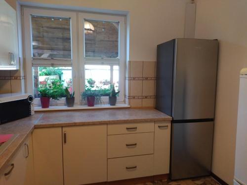 a kitchen with a refrigerator and two windows at Willa Epiona in Stepnica